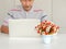 Blurred images of Asian elderly men enjoying the use of laptops on the white table, He is studying the use of modern technology.