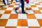 Blurred legs and shoes of group walking by across marble tiled f