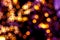 Blurred lights abstract background in the night, defocused dark glowing bokeh backdrop, magical illuminated sparkle pattern.