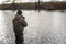 Blurred. A male angler standing in the water catches predatory fish in a cold river in the off-season. Background