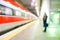 Blurred man waiting for high speed train in railwaystation - Defocused image - Original lights - Transportation, work and travel