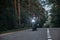 Blurred Motion A young man biker in a helmet quickly rides at high speed on a forest road, in motion