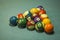 A blurred multi-colored billiard balls lie in the shape of a triangular pyramid on the blue cloth of the table