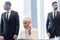 blurred multiethnic bodyguards protecting senior businesswoman