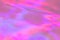 Blurred pastel neon pink, purple, blue, orange holographic foil background