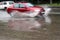 Blurred photo car rides along the road in a puddle splashing water