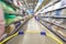 Blurred photos showcases shops on the background of a grocery cart. Long rows of racks with goods.