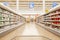 Blurred photos showcases shops on the background of a grocery cart. Long rows of racks with goods.