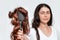 Blurred portrait of a woman holds a comb with a wig on it. White background. Concept of hair care and hair loss