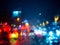 Blurred rain drops on car window with road light bokeh on rainy season abstract background