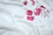 Blurred red rose corollas on a white wrinkled bedsheet