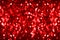 Blurred red shiny glitter bokeh background, defocused dark red shimmer backdrop design, bright red shining round bubbles blur