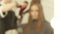 Blurred reflection in mirror hairdresser making woman hairstyling long hair with dryer and brush in beauty salon