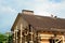 Blurred roofing construction scene with building contractors on a rooftop of a large brick house with scaffoldings