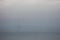 Blurred sailboat in the fog-covered sea.