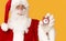 Blurred Santa holding alarm clock in hand on orange