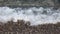 Blurred sea waves washing on the stones on the beach in the summer time