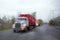 Blurred semi truck convoy in rain drops and headlight on road