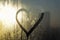 Blurred shiny background. Valentine`s Day concept. Inscription Heart shape drawn on sweaty and frosty glass window