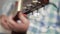 Blurred Shooting with Artist Hand in Focus Tuning the Strings of a Classic Wooden Guitar and Preparing to Play a Song in Studio.