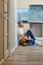 Blurred shot of professional repairman with toolbox taking a break, sitting on the floor indoors