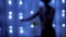 Blurred Silhouette of a Girl Dancing in a Dark Room in Flickering Garland Lights