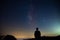 Blurred silhouette of a man observing the starry sky with the milky way