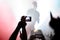 Blurred silhouette of a musician of a popular band on stage and hand from the crowd.