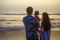 Blurred silhouette of young happy and beautiful Asian Korean couple holding baby girl daughter enjoying sunset beach together