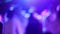 Blurred silhouettes of people dancing at a party in a nightclub. Soft focus, slow motion. Party with neon laser lights. Have fun t