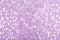 Blurred silver foil confetti on purple background