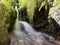 Blurred stream of a mountain stream bounces off a stone