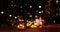 Blurred street with buildings, cars and light spots