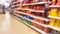 Blurred supermarket aisles with various products on display, store interior as background