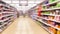 Blurred supermarket aisles with various products on display, store interior as background