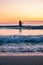 Blurred surfer on longboard. small waves during beautiful sunset. surfing behind arctic circle has advantage of midnight sun