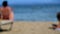 Blurred Time Lapse People Sunbathe On Beach of Ionian Sea, Moraitika, Greece. High quality 4k footage