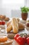 Blurred tomatoes and jam on dining table with baguettes on wooden desk