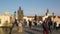 Blurred tourists walking faster on city bridge during sunset