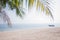 Blurred tropical palm leaves over sandy beach sea with fishing b