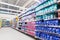 Blurred variety of bleach, fabric softener, laundry detergent on shelves at grocery store supermarket