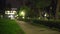 Blurred video background plate of empty path in dark urban park at night