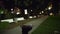 Blurred video background plate of empty urban park at night with benches