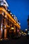 Blurred view of beautiful cityscape with glowing streetlights and illuminated building in evening