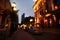 Blurred view of beautiful cityscape with glowing streetlights and illuminated building in evening