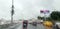 Blurred view from car on raindrops on window and road with silhouettes of cars driving behind him in rainy evening