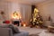 Blurred view of festively decorated room with Christmas tree near fireplace