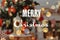 Blurred view of stylish and phrase Merry Christmas. Holiday greeting card design
