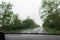 Blurred view of suburban road through wet car window