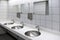 Blurred white washbasins and shiny faucets in toilet with flare